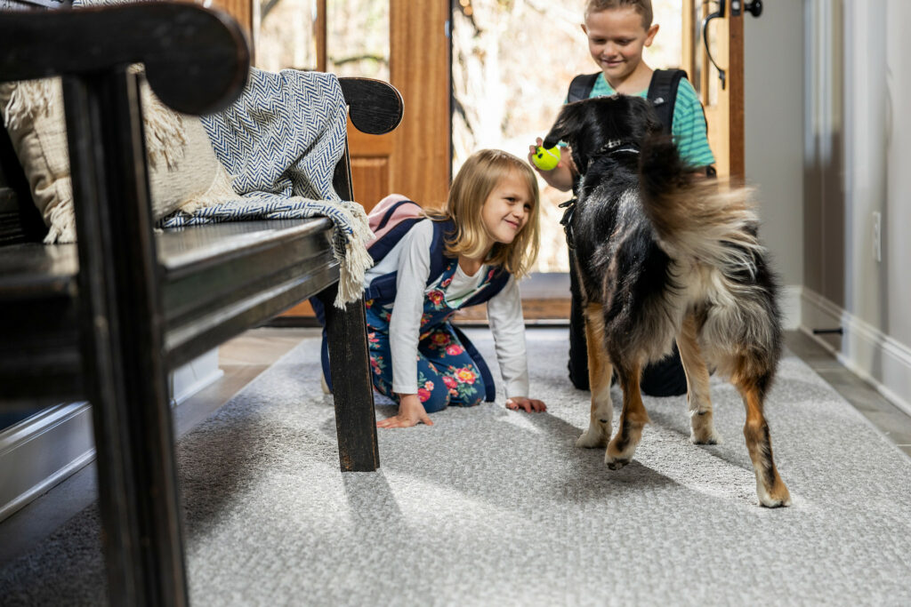 Kids playing with dog on carpet floor | Tom January Floors